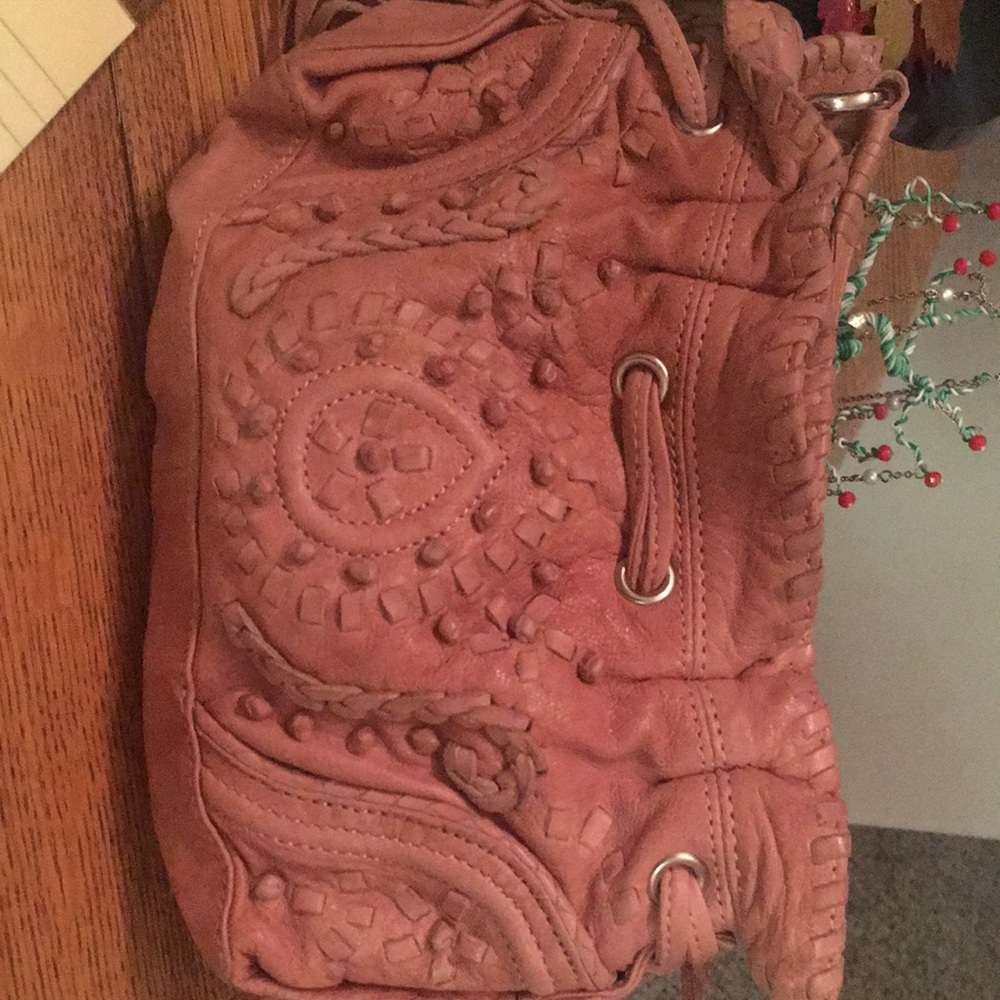 A cute leather small bag with adjustable strap , fringe tassels